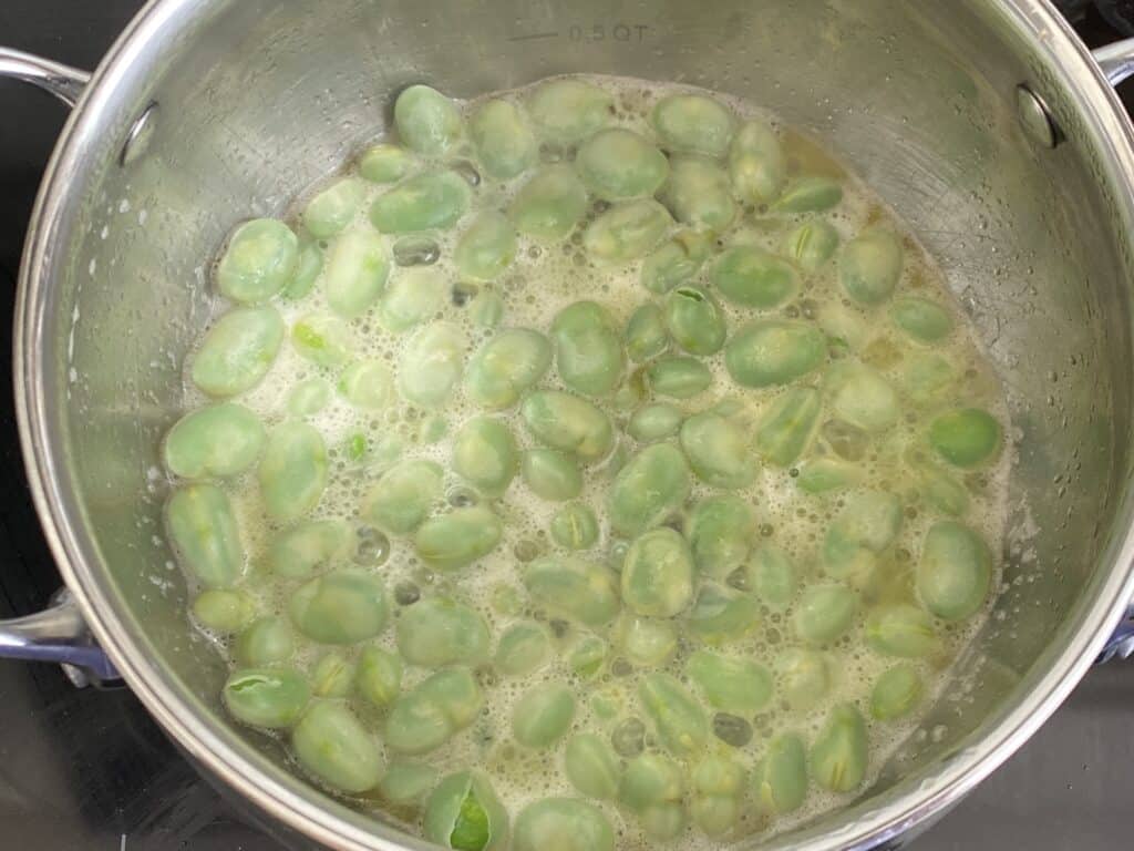 Gently simmer the beans in butter and water